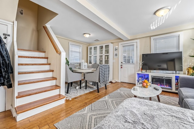 living room featuring light hardwood / wood-style flooring and beamed ceiling