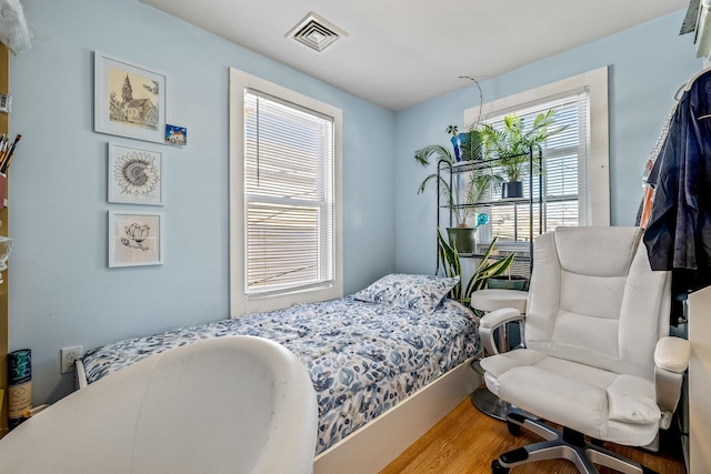 bedroom with multiple windows and wood-type flooring