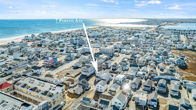 drone / aerial view featuring a water view and a beach view