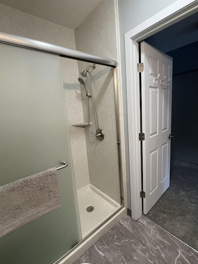 bathroom featuring a shower with door and a textured ceiling