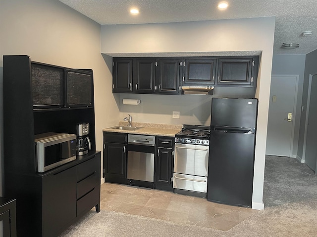 kitchen featuring sink, light colored carpet, a textured ceiling, and appliances with stainless steel finishes