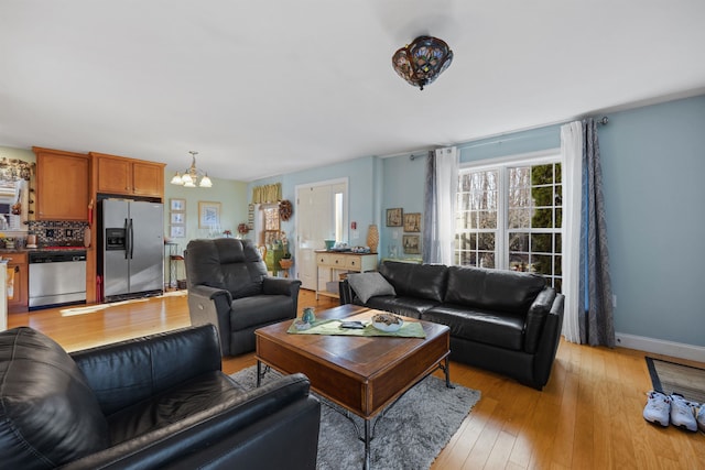 living room with a chandelier and light wood-type flooring