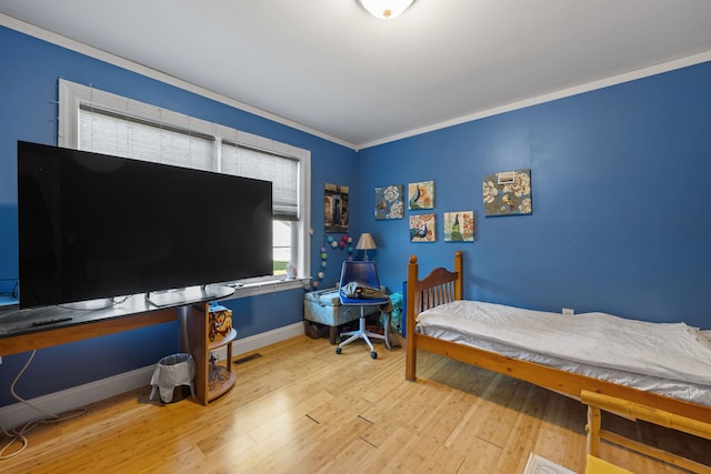 bedroom with hardwood / wood-style floors and ornamental molding