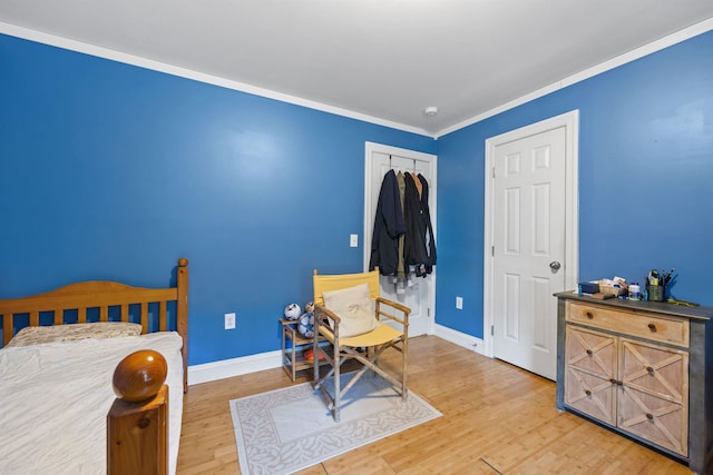 bedroom featuring hardwood / wood-style floors, crown molding, and a closet