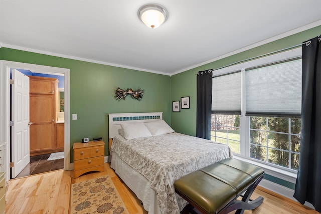 bedroom with light wood-type flooring and crown molding