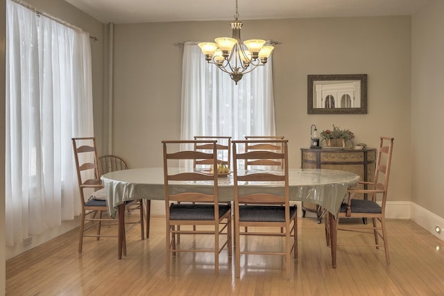 dining room featuring plenty of natural light, light hardwood / wood-style floors, and an inviting chandelier