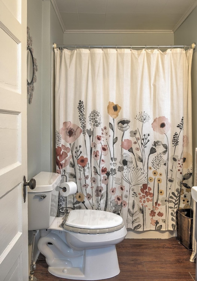 bathroom featuring hardwood / wood-style flooring, toilet, walk in shower, and crown molding