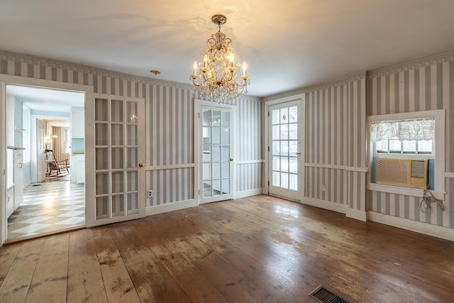 unfurnished dining area with cooling unit, wood-type flooring, and a chandelier