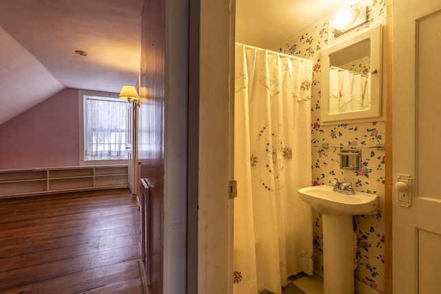 bathroom featuring lofted ceiling and wood-type flooring