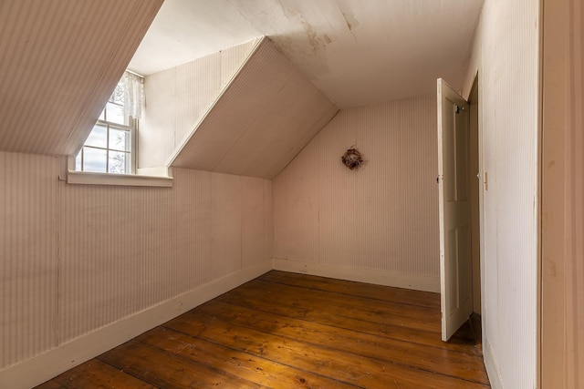 bonus room with hardwood / wood-style flooring and vaulted ceiling