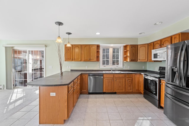 kitchen with kitchen peninsula, appliances with stainless steel finishes, light tile patterned floors, and pendant lighting