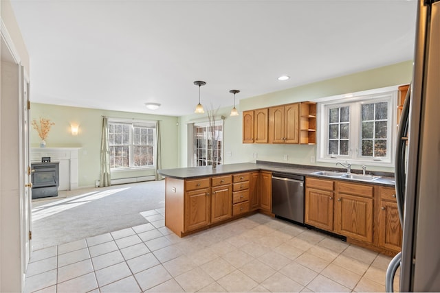 kitchen featuring sink, kitchen peninsula, pendant lighting, light carpet, and appliances with stainless steel finishes