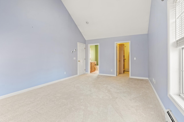 unfurnished bedroom featuring baseboard heating, ensuite bath, high vaulted ceiling, and light colored carpet