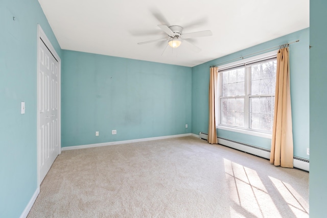 unfurnished bedroom featuring ceiling fan, a baseboard heating unit, light colored carpet, and a closet