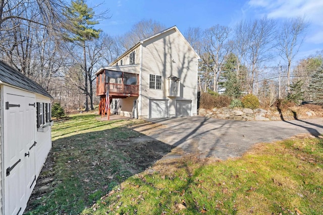 rear view of house with a garage and a deck