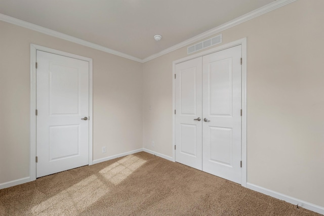 unfurnished bedroom with carpet, a closet, and ornamental molding