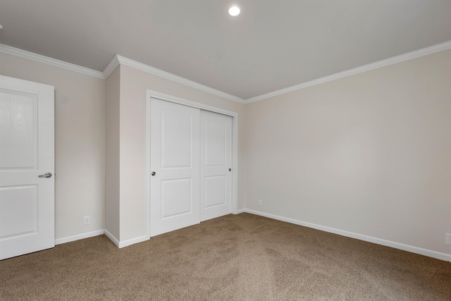 unfurnished bedroom featuring carpet floors, crown molding, and a closet