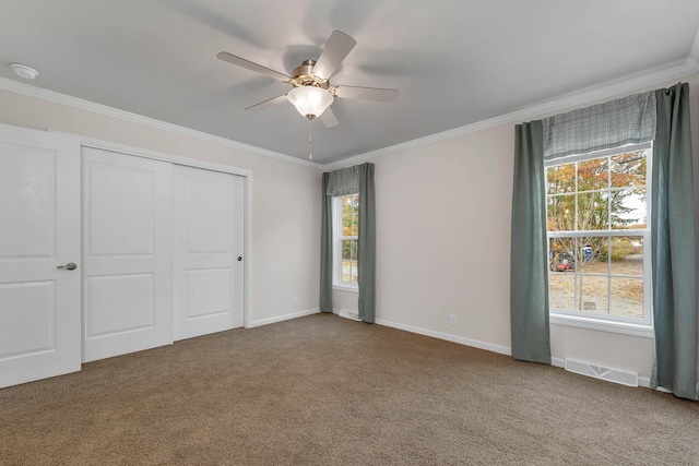 unfurnished bedroom featuring carpet, ceiling fan, ornamental molding, and a closet