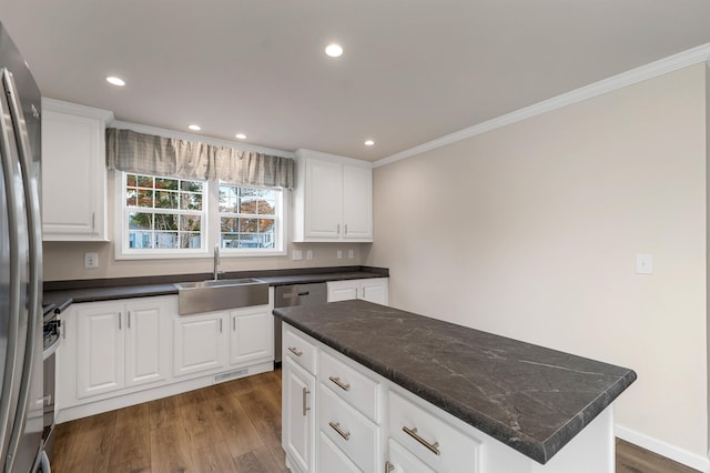 kitchen featuring white cabinets, appliances with stainless steel finishes, dark hardwood / wood-style flooring, and a kitchen island