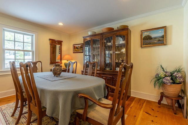 dining space featuring hardwood / wood-style floors and crown molding