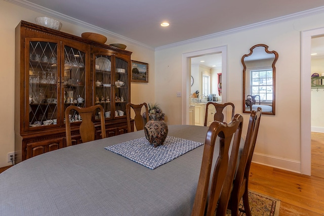 dining space with hardwood / wood-style floors and ornamental molding