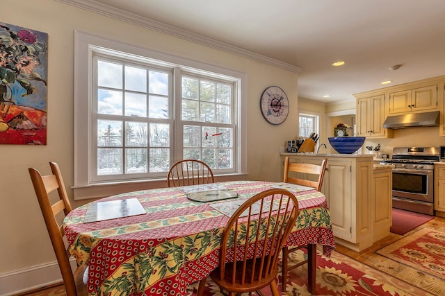 dining area with crown molding and light hardwood / wood-style floors