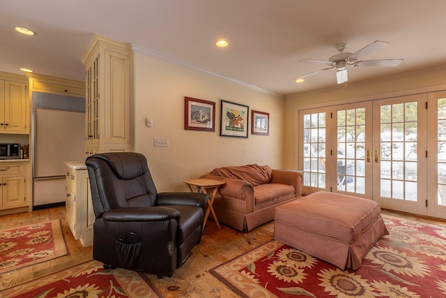 living room featuring french doors, light hardwood / wood-style floors, ceiling fan, and ornamental molding