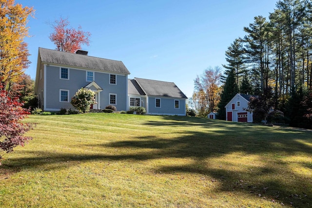 rear view of property with a yard and an outdoor structure