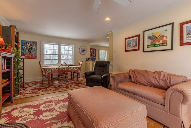 living room with ceiling fan, light wood-type flooring, and crown molding