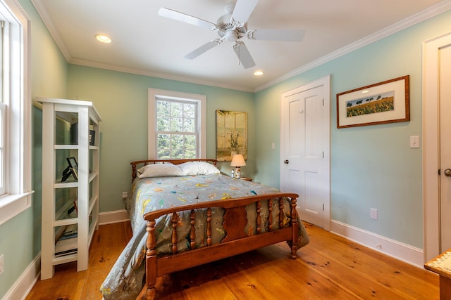 bedroom featuring ceiling fan, light hardwood / wood-style floors, and crown molding