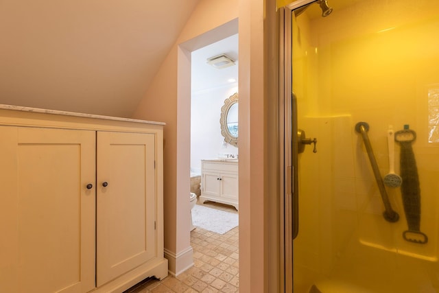 bathroom featuring a shower with door, vanity, lofted ceiling, and toilet