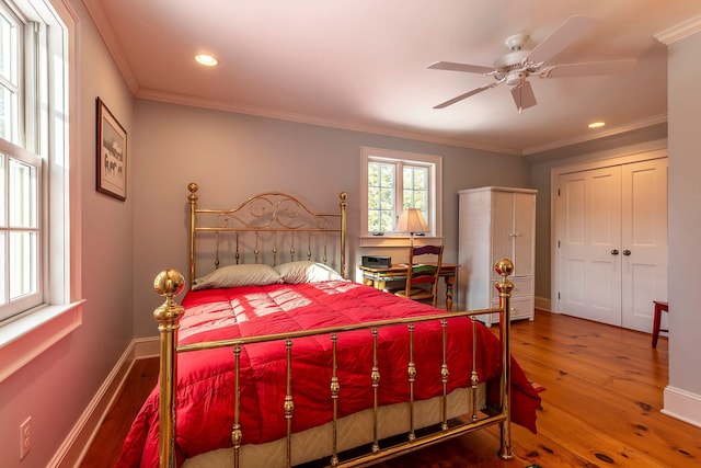 bedroom featuring ceiling fan, hardwood / wood-style floors, and crown molding