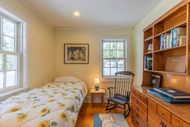 bedroom featuring crown molding and light hardwood / wood-style flooring