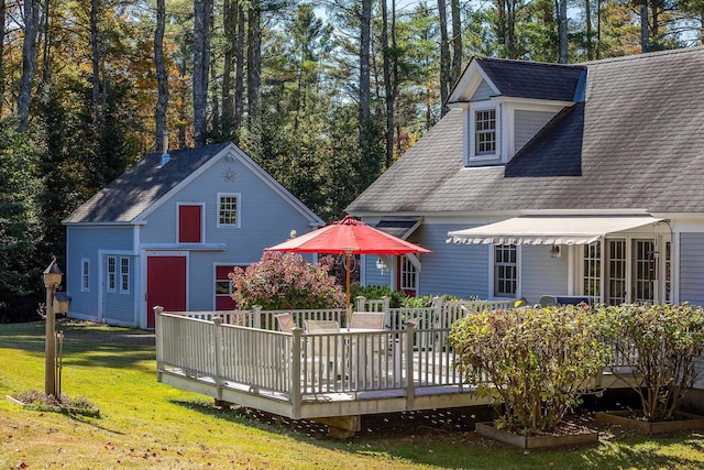 back of property with a lawn and a wooden deck