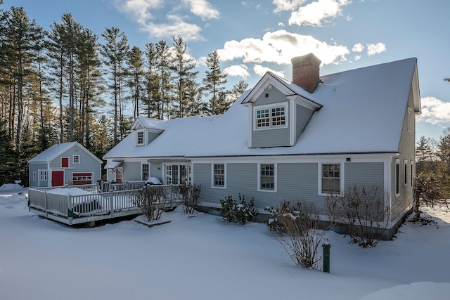 snow covered back of property featuring a deck