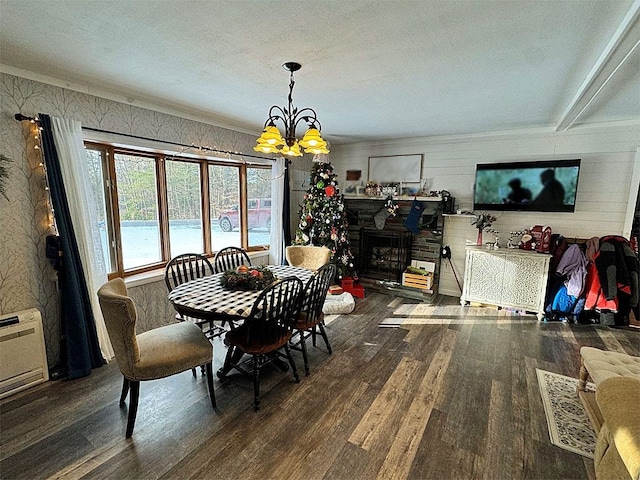 dining room with dark wood-type flooring, a chandelier, a textured ceiling, and ornamental molding