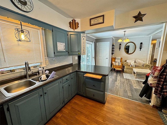 kitchen featuring hardwood / wood-style floors, pendant lighting, sink, and tasteful backsplash