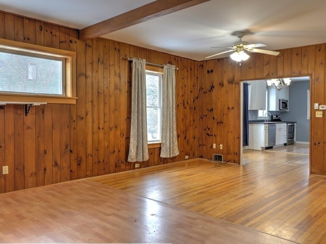 unfurnished living room featuring wooden walls and hardwood / wood-style floors