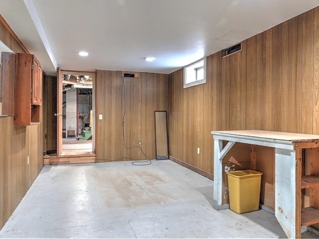 basement featuring wood walls