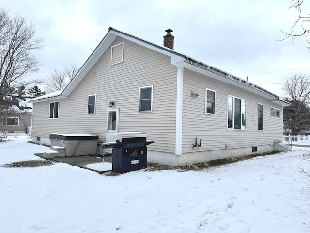 snow covered property with a hot tub