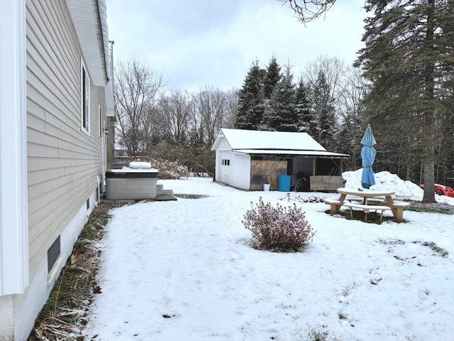 yard layered in snow featuring an outdoor structure