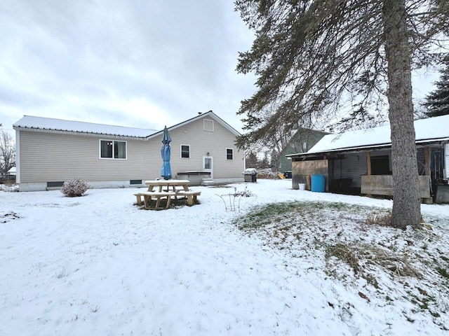 view of snow covered back of property