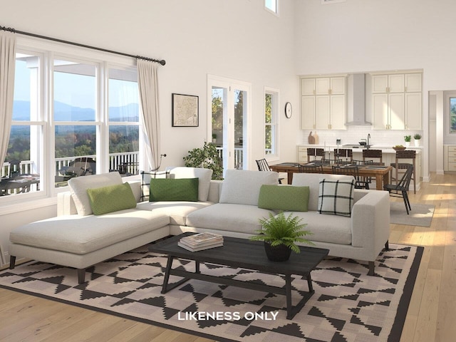 living room with a mountain view, light wood-type flooring, a wealth of natural light, and a towering ceiling