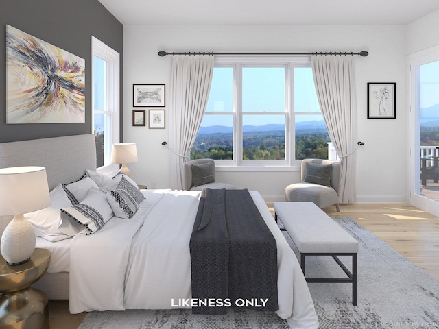 bedroom featuring a mountain view and light hardwood / wood-style flooring