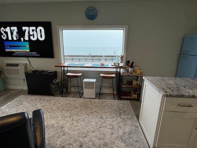 dining area with hardwood / wood-style flooring and a wall mounted air conditioner