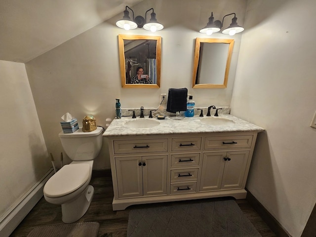 full bath with double vanity, wood finished floors, toilet, and a sink