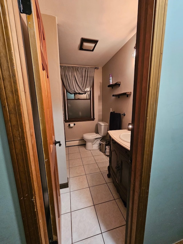 bathroom featuring tile patterned flooring, toilet, vanity, and baseboard heating