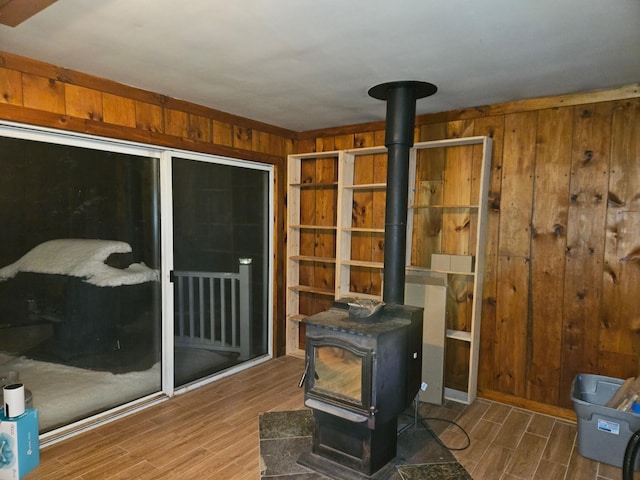 interior space featuring a wood stove, wooden walls, and wood tiled floor