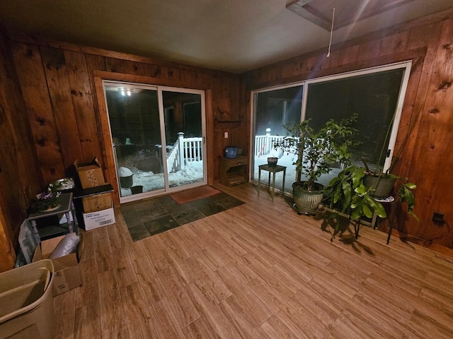 interior space featuring attic access, wood finished floors, and wood walls