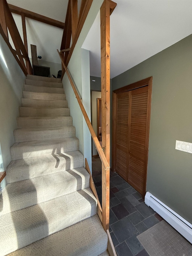 stairs featuring stone tile flooring and baseboard heating